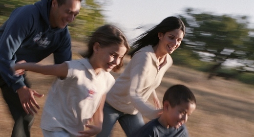 Family In Park Running In Field